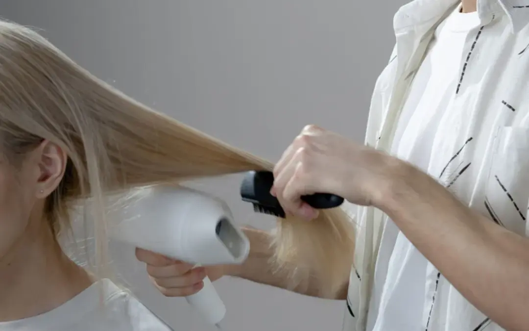 A stylist blow-drying a client at CHAIR