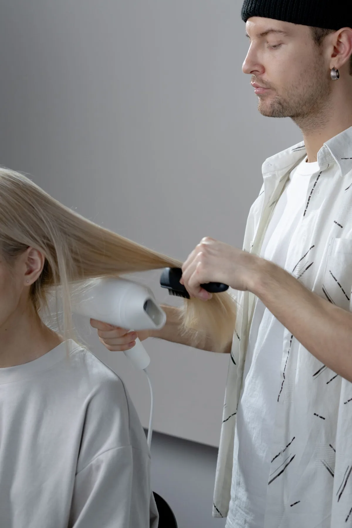 A stylist blow-drying a client at CHAIR