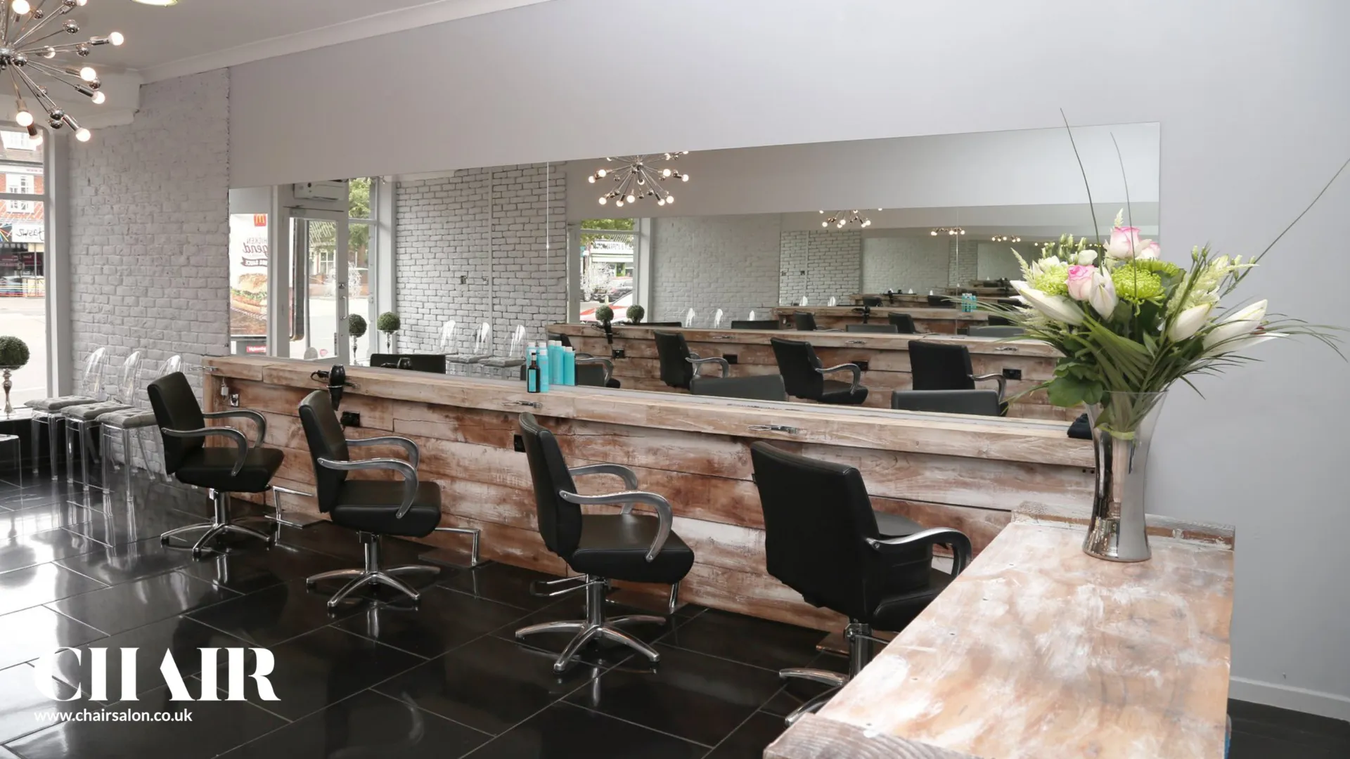 The styling floor at CHAIR, with mirrors, reclaimed wood stations and salon chairs